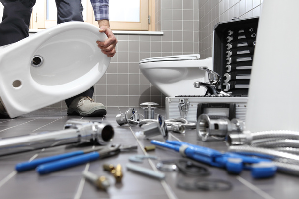 plumber at work in a bathroom, plumbing repair service, assemble - Fotó, kép