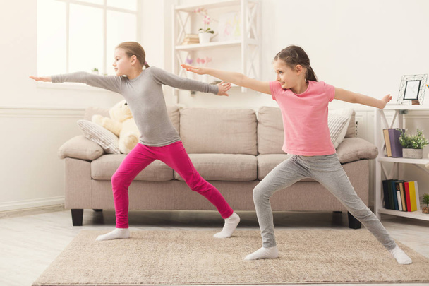 Little girls training yoga in hero pose together indoors - Fotó, kép