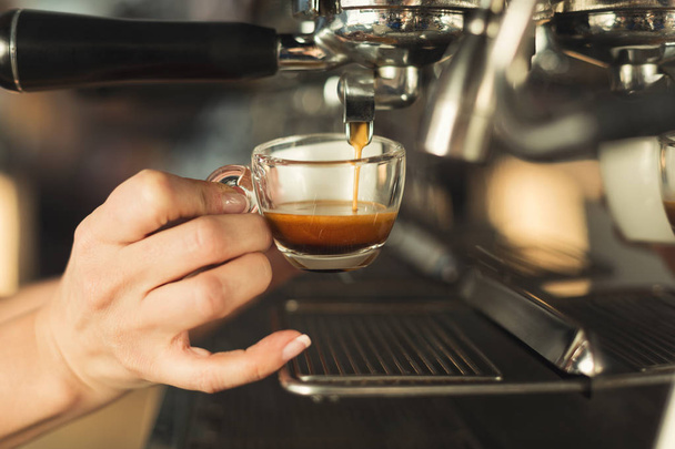 Closeup of barmen hand brewing espresso in professional coffee machine - Foto, imagen