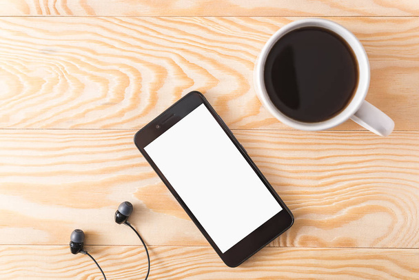 Kawa, telefon oraz słuchawki na jasnym tle drewnianych - Zdjęcie, obraz