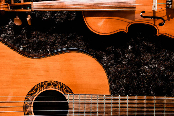 klassische Gitarre und Geige aus nächster Nähe auf dunklem Hintergrund - Foto, Bild
