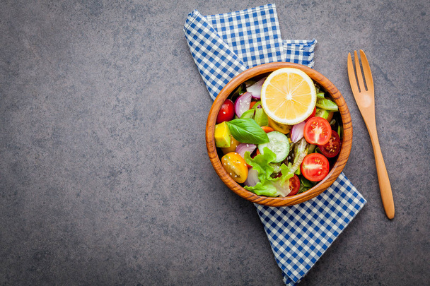A tigela de salada vegan saudável. Vários legumes abacate, tomate, pepino, repolho vermelho, manjericão e cebola no fundo de pedra escura
 . - Foto, Imagem