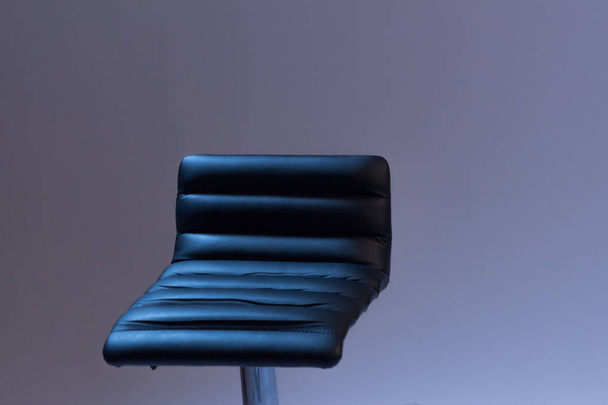 The bar stool is made of black leather. Close-up. Gray background. - Valokuva, kuva