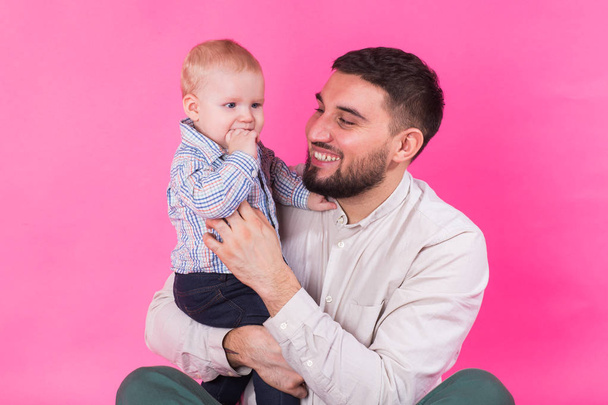 Portret szczęśliwy ojciec i syn na różowym tle. W studio - Zdjęcie, obraz