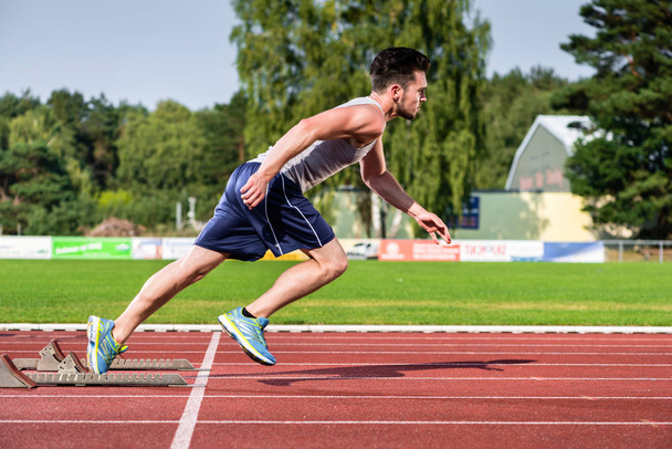 Atleta en pista de cemento de las instalaciones deportivas comienza a correr
 - Foto, Imagen