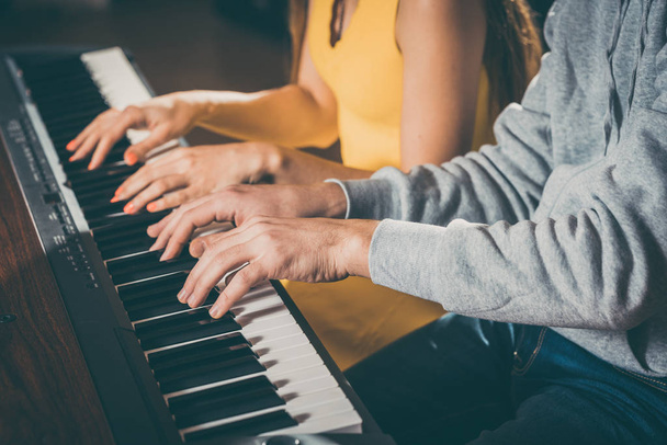 Pianistas tocando juntos con cuatro manos
 - Foto, Imagen