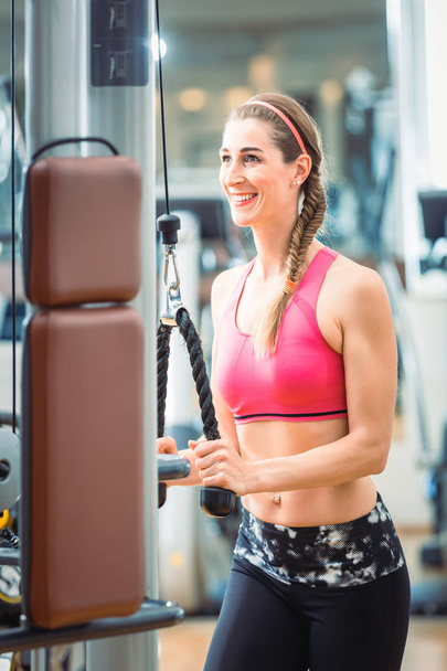 Счастливая женщина в розовом спортивном лифчике во время тренировки в спортзале
 - Фото, изображение