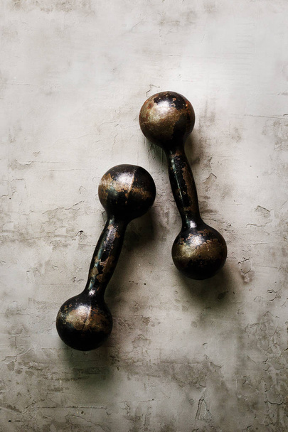 Old dumbbells on concrete background. Sport concept. Free space for your text. - Foto, Imagen