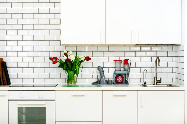 Fresh bouquet of red and white tulips on kitchen table. Detail of home interior, design. Minimalistic concept. Flowers for mother, girl, wife, woman. Copy space. - Φωτογραφία, εικόνα
