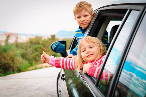 happy kids travel by car on road in nature - Photo, Image