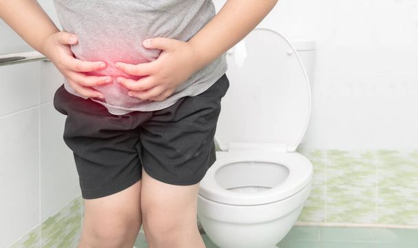товстий хлопчик страждає шлунком і сидить у туалеті, діарея
  - Фото, зображення