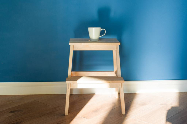 One cup stands on a wooden chair. - Фото, зображення