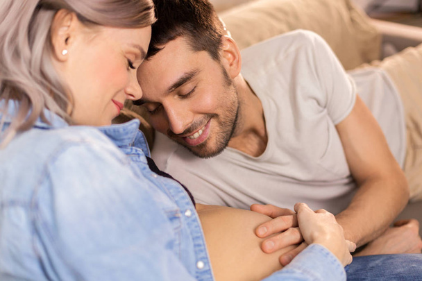 happy man with pregnant woman at home - Zdjęcie, obraz