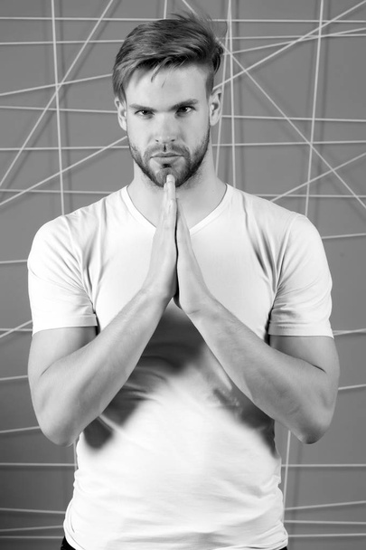 Bearded man in white tshirt with praying hands. Bearded macho with beard on unshaven face, black and white - Foto, afbeelding