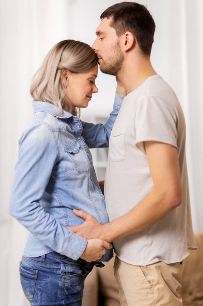 happy man with pregnant woman at home - Photo, Image