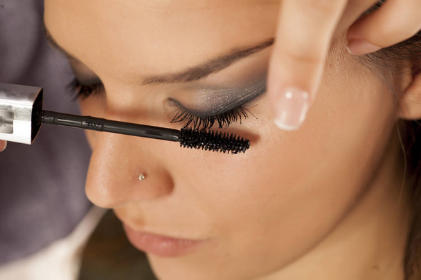 Closeup of a makeup artist applying mascara - 写真・画像