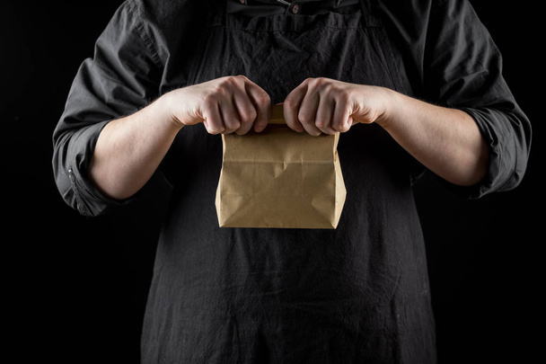 Cropped view of chef holding craft paper bag - Foto, Imagem