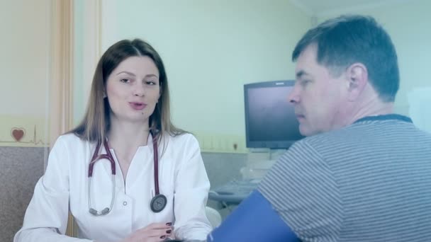 Mujer médico ayuda a usar un dispositivo de diagnóstico del corazón para el paciente
 - Metraje, vídeo
