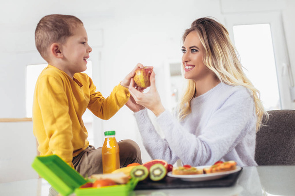 Матері прийняття сніданку на своїх дітей вранці і закуски для школи - Фото, зображення