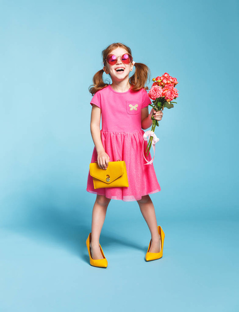 funny child girl fashionista in big mother's   shoes on colored  - Zdjęcie, obraz