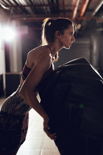 Giovane donna muscolare ribaltamento pneumatico sulla formazione crossfit
 - Foto, immagini