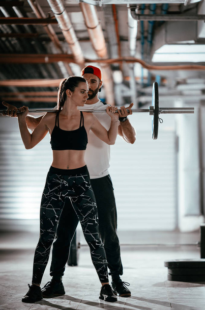 Молодая мускулистая женщина делает перекрестные тренировки с личным тренером
  - Фото, изображение