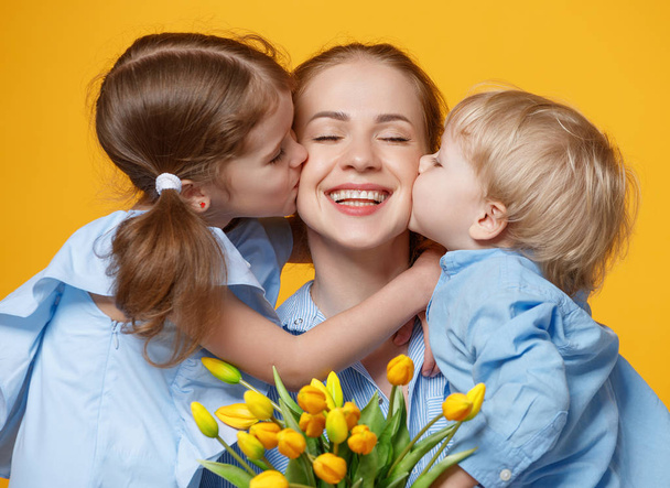 Концепция Дня матери. мама и дети с цветами на цветной
 - Фото, изображение