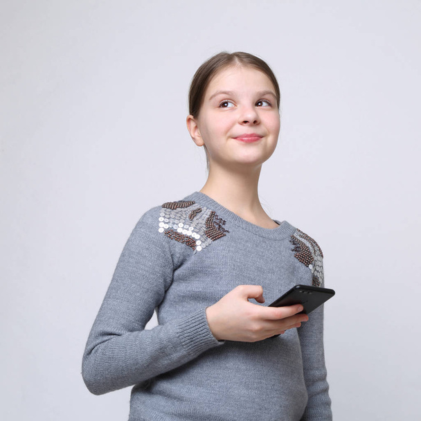 School teen girl holding mobile phone (smartphone) - Φωτογραφία, εικόνα