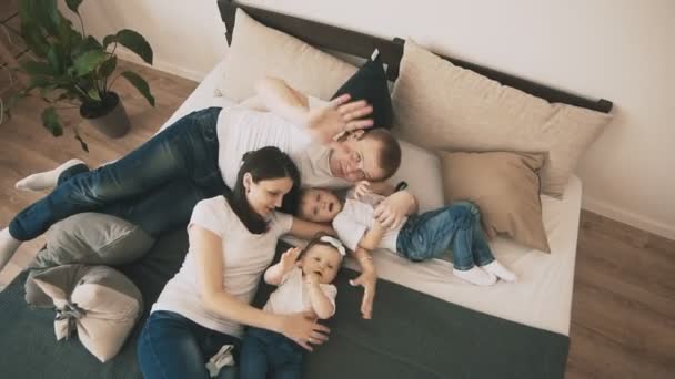 Family playing on bed at home in slom. Top view. Young family have fun indoor - Záběry, video