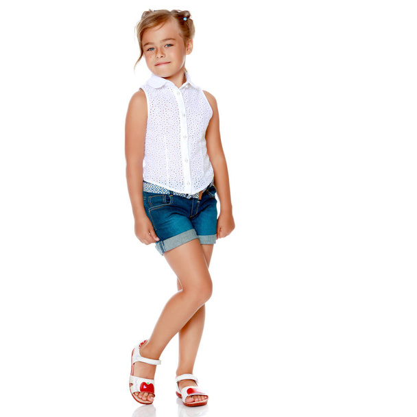 A little girl in shorts and a white shirt. - Photo, Image