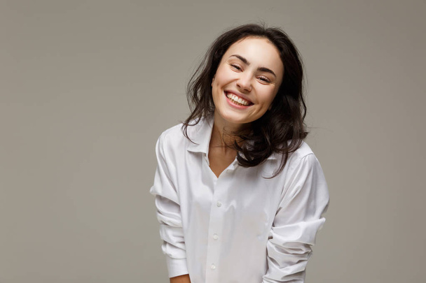 Beautiful girl in a white shirt shows emotions - smile, fun. - Fotoğraf, Görsel