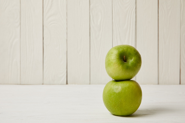 Два сирих свіжих зелених яблука на дерев'яному фоні з копіювальним простором
 - Фото, зображення