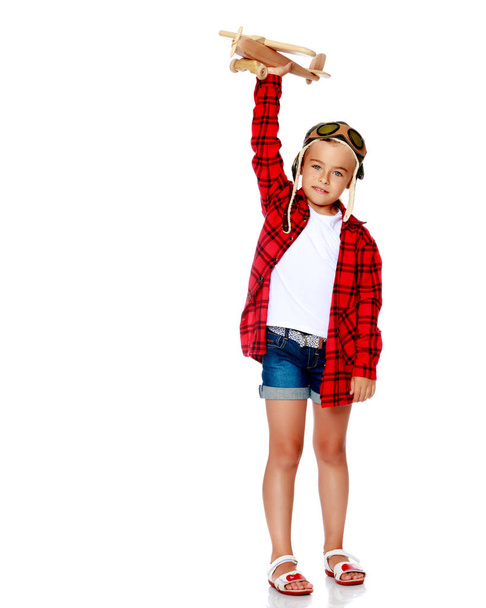 Egy kislány egy fa repülővel a kezében.. - Fotó, kép