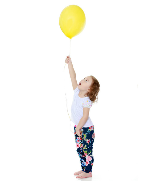 Little girl is playing with a balloon - Fotó, kép