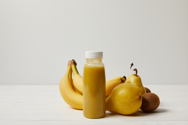 yellow smoothie with bananas, kiwis and pears on white background   - Φωτογραφία, εικόνα