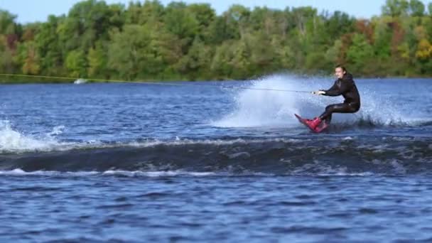 Wakeboarder salta in alto sopra l'acqua. Rider wakeboarding
 - Filmati, video