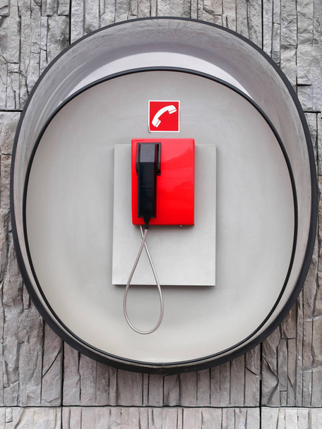 Photo of red phone on gray wall of modern building - Photo, Image