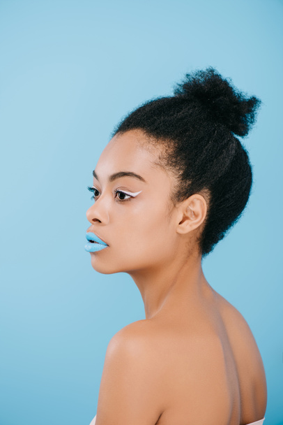 attractive young woman with creative makeup looking away isolated on blue - Фото, изображение