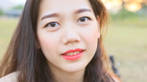 Закрыть зубастое улыбающееся лицо молодой азиатки
  - Кадры, видео