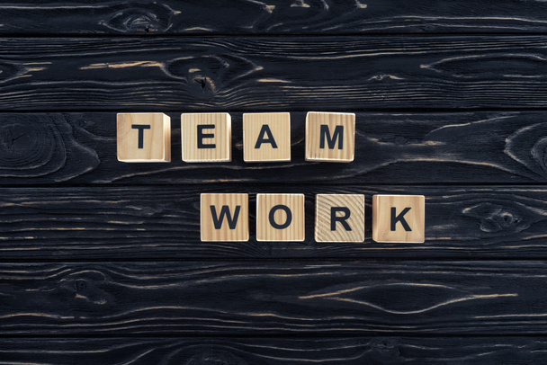 top view of word team work made of wooden blocks on dark wooden tabletop - Fotografie, Obrázek