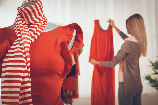 Nuori nainen valitsemalla vaatteet putiikki
 - Valokuva, kuva