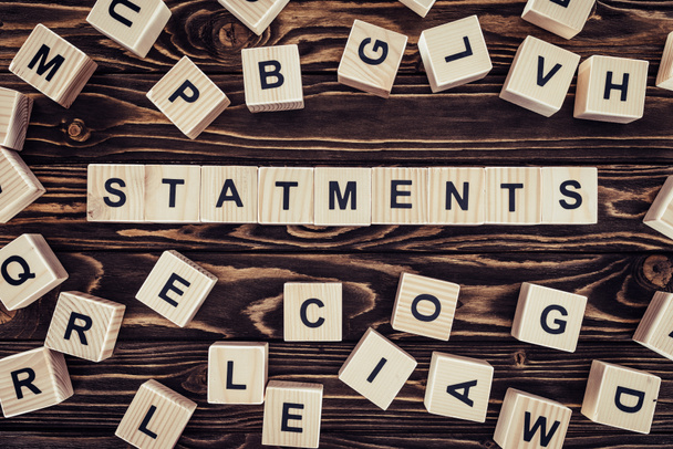 top view of of word statements made of wooden blocks on wooden surface  - Photo, Image