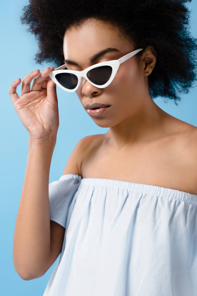 schöne junge Frau in stylischer Retro-Sonnenbrille isoliert auf blau - Foto, Bild