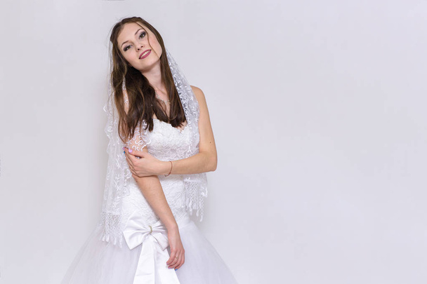 beautiful bride in white wedding dress in different poses on white backgrounds shows different emotions - Foto, afbeelding