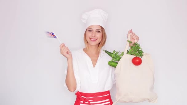 Nainen kokki yhtenäinen tilalla laukku eri vihanneksia ja Britannian lippu
  - Materiaali, video