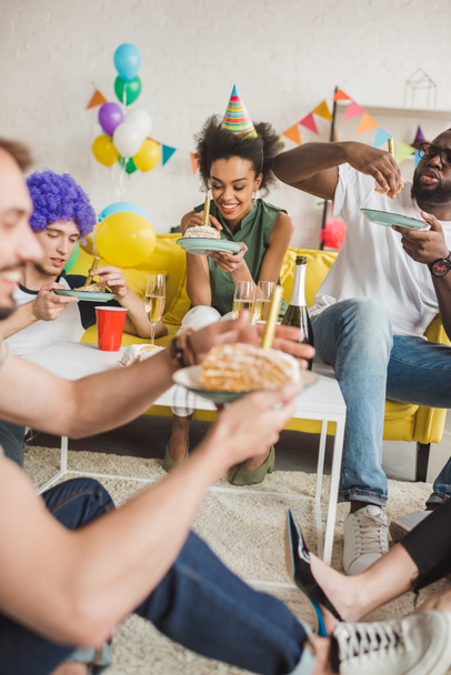 Partying diverse people eating birthday cake and holding drinks - Foto, immagini