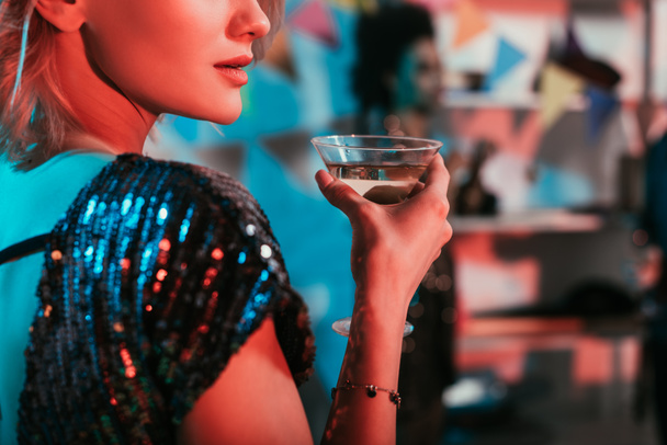 Blonde woman holding glass with cocktail at party - Photo, Image