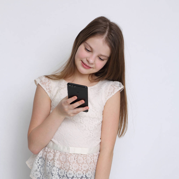 School teen girl holding mobile phone (smartphone) - Fotografie, Obrázek