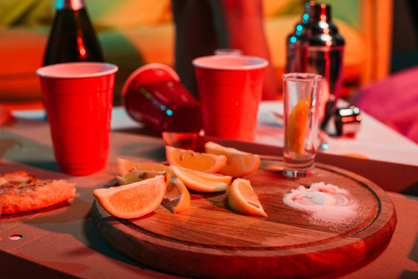 Plastik bardak içecek ve parti masada dilimlenmiş portakal ile - Fotoğraf, Görsel