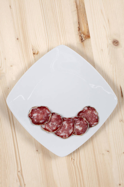 plasterki salami na biały danie - Zdjęcie, obraz